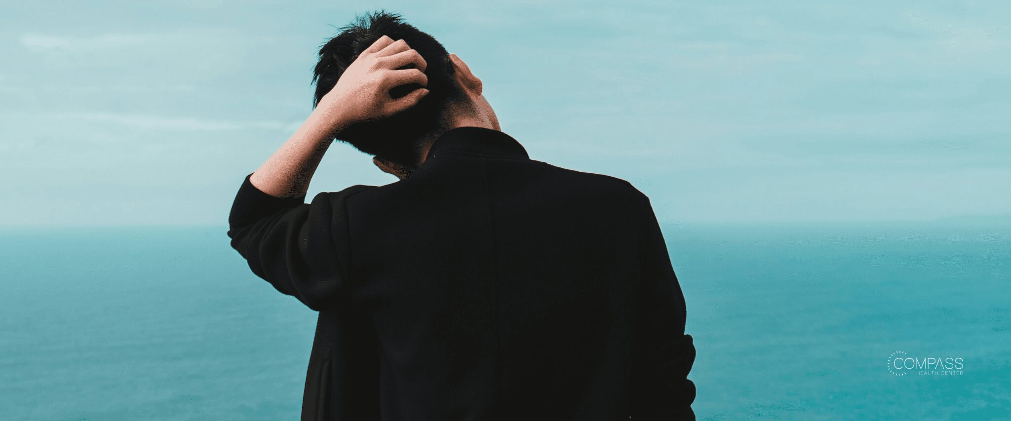 A man standing at a cliffside, scratching the back of his head Image source: Unsplash