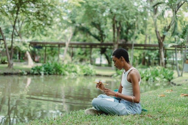 Woman holding a pencil and paper in the park