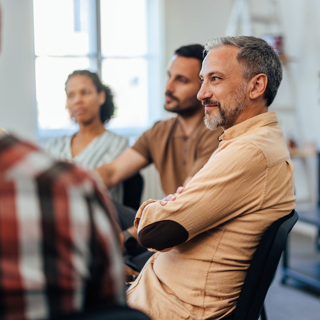 People sitting around each other in a support group