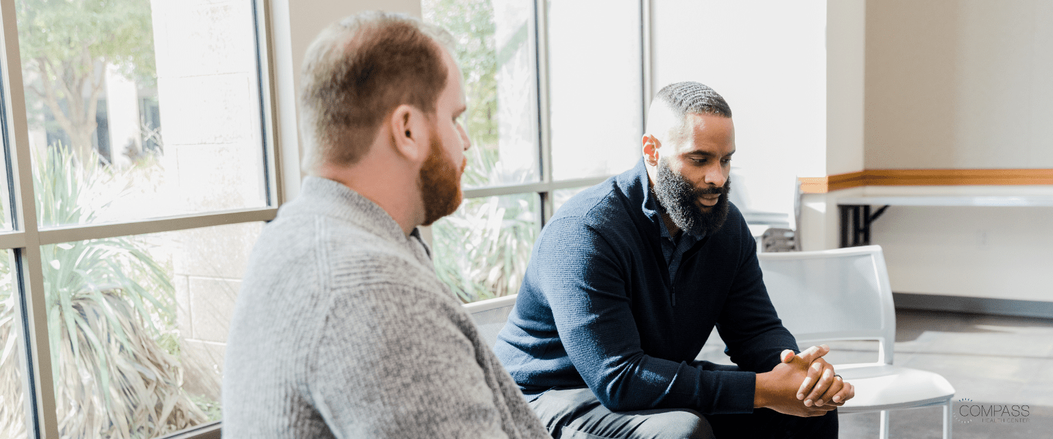 Two males talking in a group therapy session