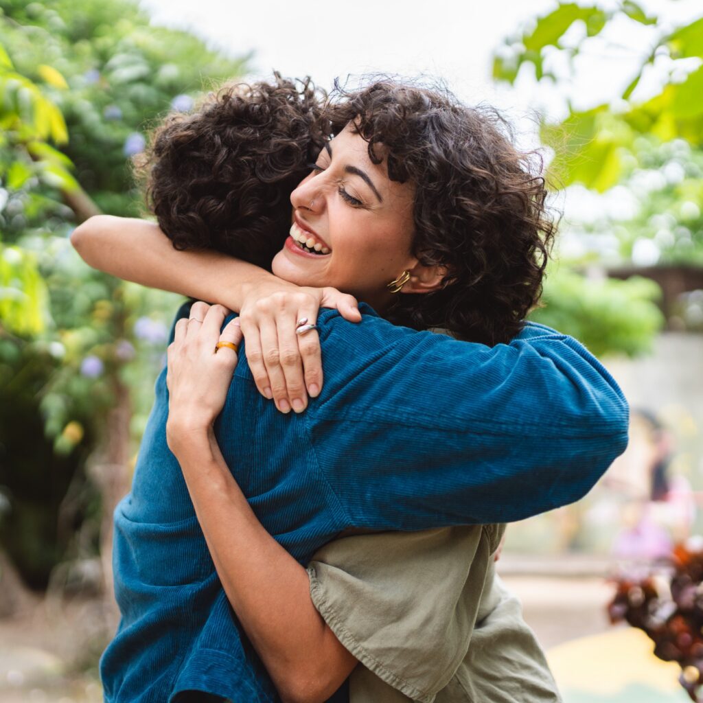 young woman hugging a friend and smiling