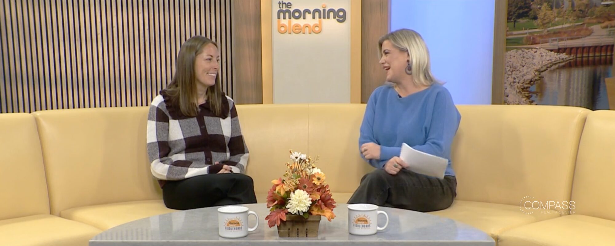Two women sit on a yellow couch in the TMJ4 News studio.