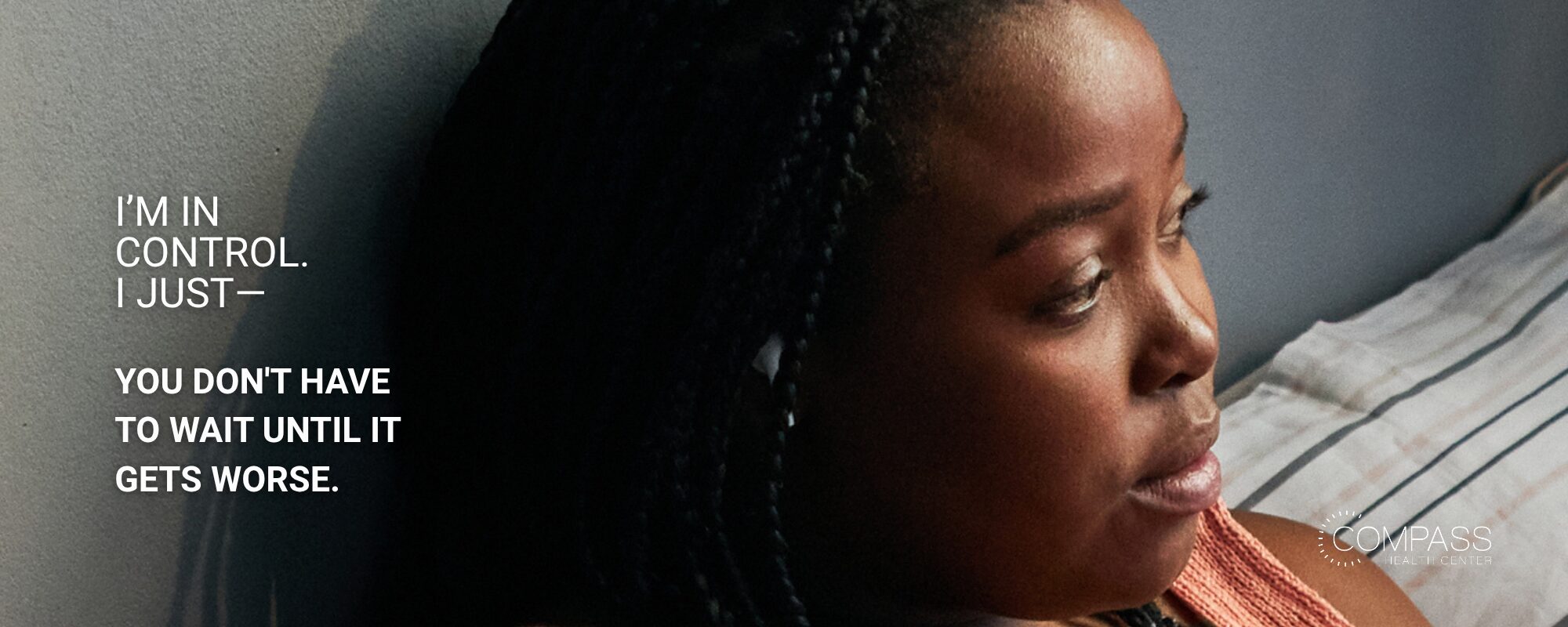 A close-up profile of a woman with long braids looking off to the side with a pensive expression, leaning against a wall near a striped pillow. White text on the left reads “I’m in control. I just—” followed in bold by “You don’t have to wait until it gets worse.” The Compass Health Center logo appears in the bottom right corner.