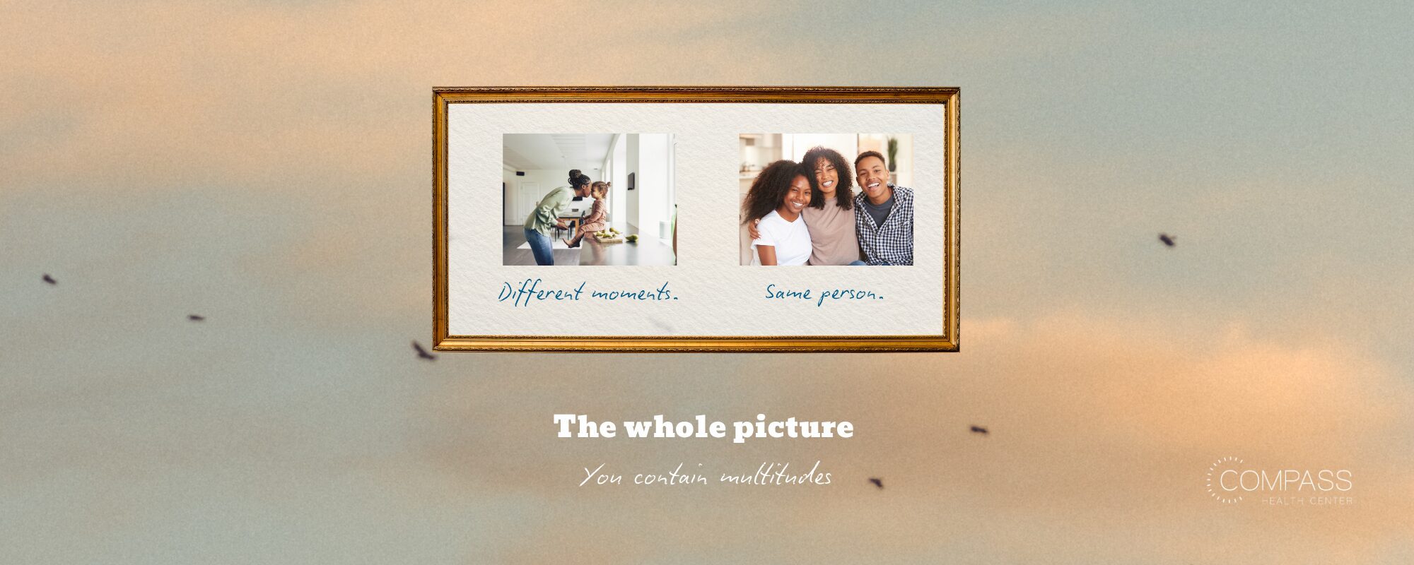 A framed picture against a soft, hazy sky background with birds flying in the distance, showing two side-by-side photos: one of a parent and young child in a kitchen, and one of three smiling family members with curly hair embracing. Handwritten captions read "Different moments" and "Same person." Below the frame, text reads "The whole picture, You contain multitudes," with the Compass Health Center logo in the bottom right corner.